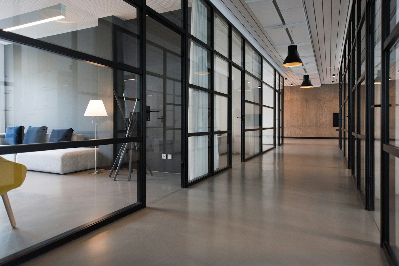 Pasillo de oficina con puertas y muros de vidrio