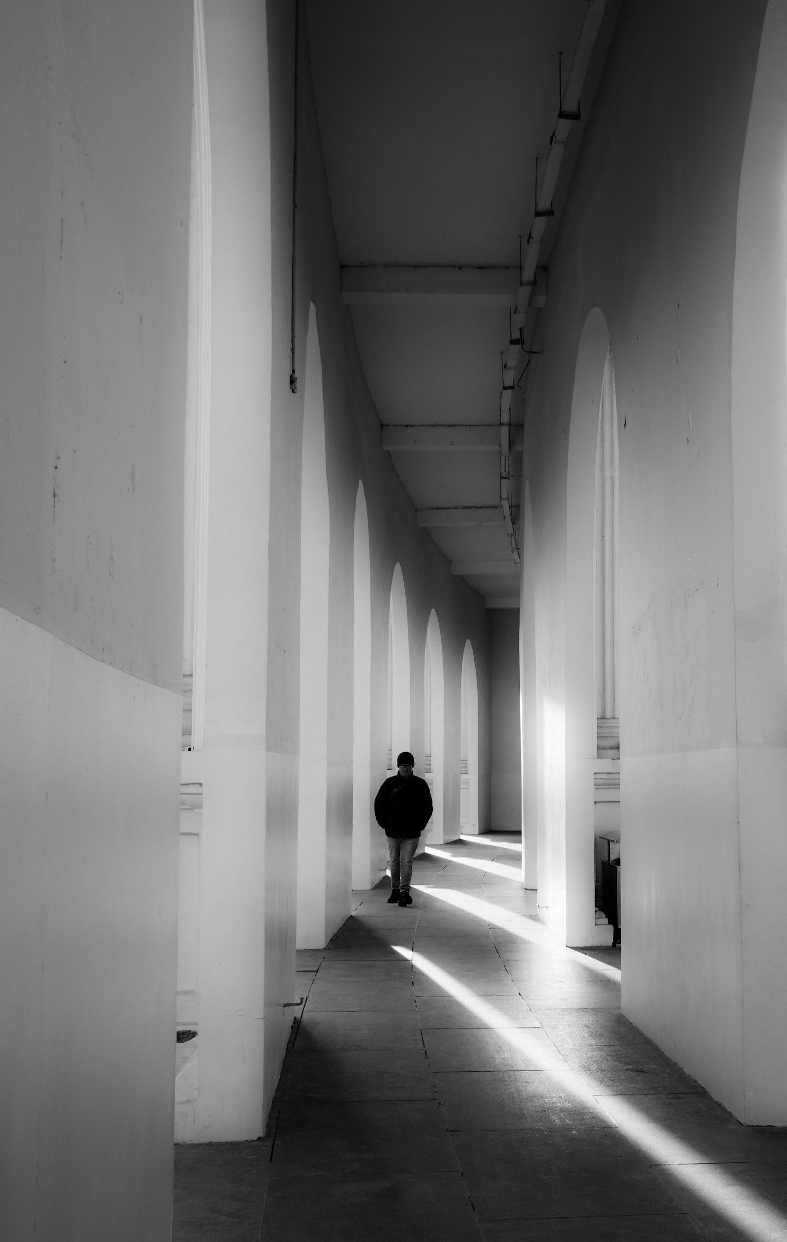 Una persona camina sola por un pasillo largo y luminoso