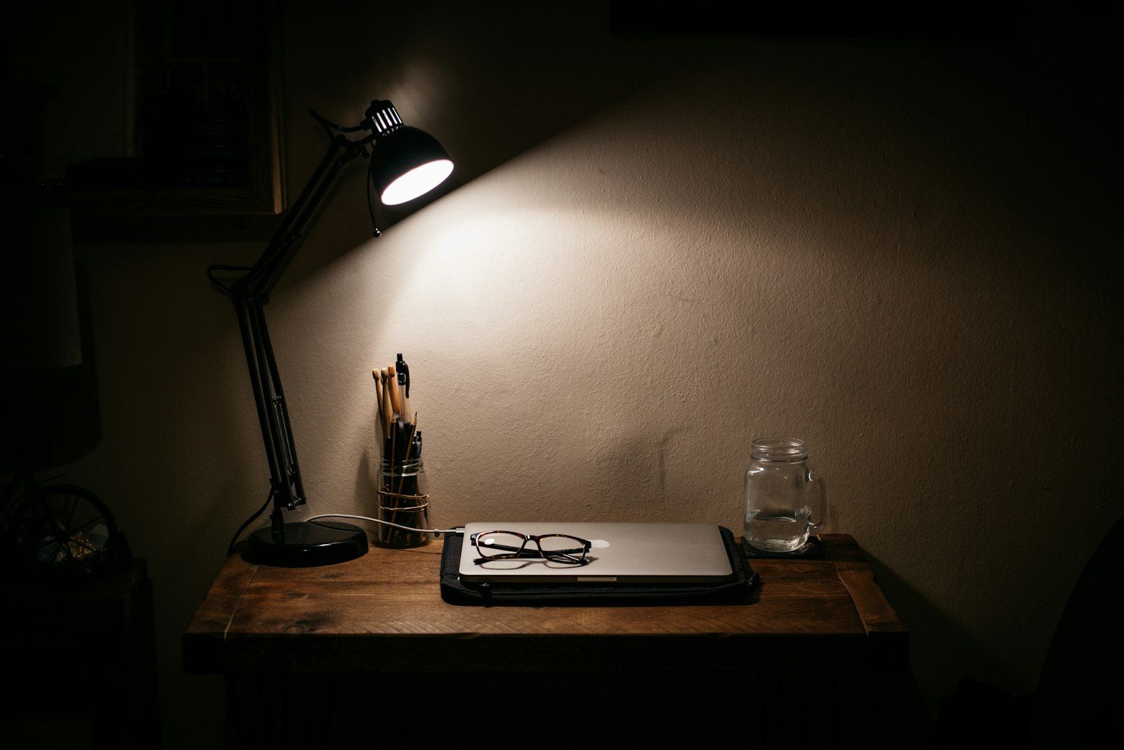 Lámpara de escritorio encendida sobre una mesa de trabajo